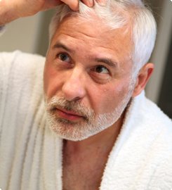 Mann studerer håret med behandling